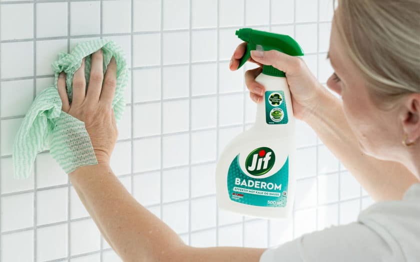 Kvinne vasker fliser med Jif Baderom.
