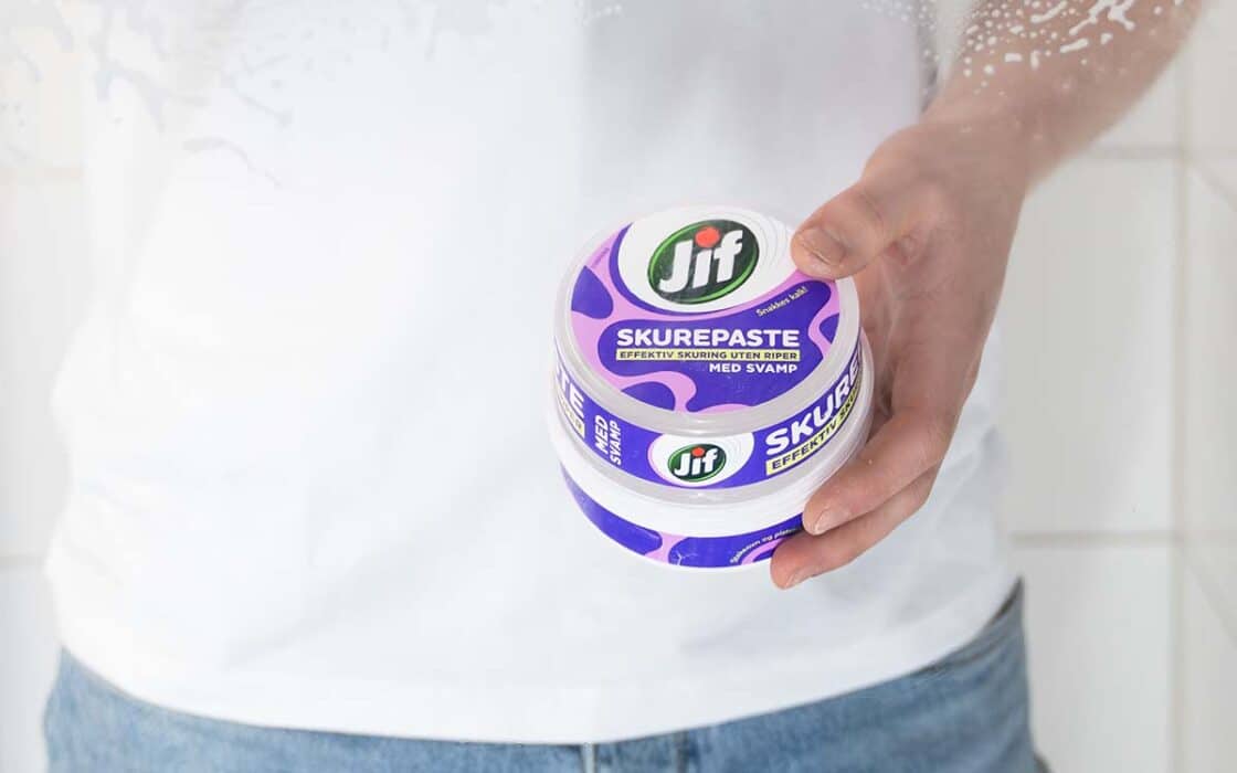 Mann vasker dusjdørene med Jif Skurepaste.